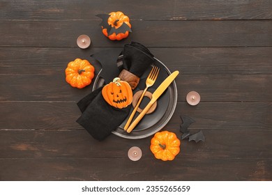 Halloween table setting with tasty cookie on dark wooden background