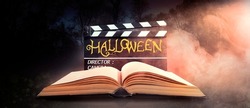 Halloween. Text Title On Film Slate Or Movie Clapperboard And Old Book In Nightmare Forest.