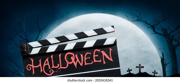 Halloween. Text Title On Film Slate Or Movie Clapperboard. The Full Moon On Graveyard Silhouette Abstract Background.