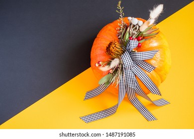 Halloween Or Thanksgiving Background. Autumn Composition In Pumpkin With Ribbons And Dried Flowers On Duo Tone Background With Copy Space.