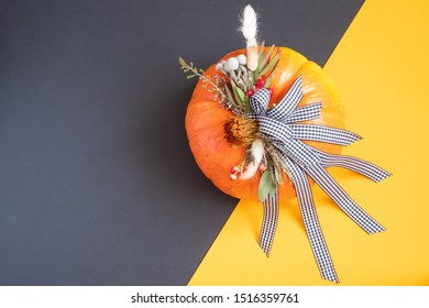 Halloween Or Thanksgiving Background. Autumn Composition In Pumpkin With Ribbons And Dried Flowers On Duo Tone Background With Copy Space.