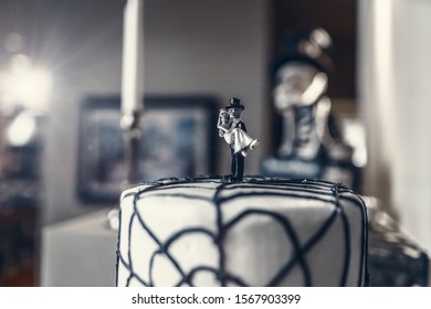 A Halloween Themed White Fondant Wedding Cake With A Skeleton Bride And Groom Topper And Web Frosting Decoration. 