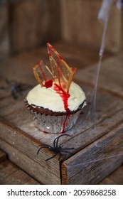 Halloween Treat Chocolate Cupcake With White Frosting Impaled With Glass Shards That Ooze Red Blood Sauce