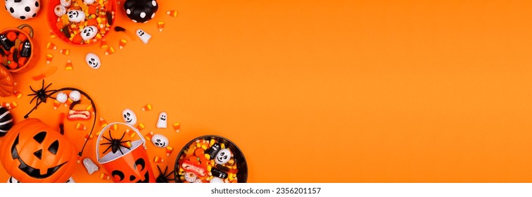 Halloween trick or treat corner border with jack o lantern pails and a variety of candy. Top down view on an orange banner background with copy space. - Shutterstock ID 2356201157