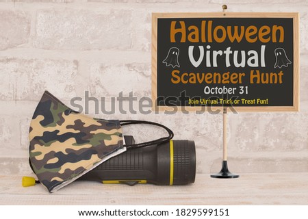 Halloween Virtual Scavenger Hunt October 31 sign next to homemade face mask and  black flashlight