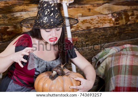 halloween, witch with big achatine snails on a wooden background