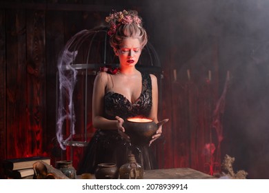 Halloween Witch With Cauldron. Beautiful Young Woman Conjuring, Making Witchcraft. Standing Spooky Dungeon Dark Room. Enchantress Prepare Love Potion Use Magic Spell