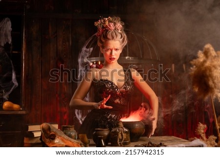 Halloween witch with cauldron. Beautiful young woman conjuring, making witchcraft. Standing spooky dungeon dark room. Enchantress prepare love potion use magic spell
