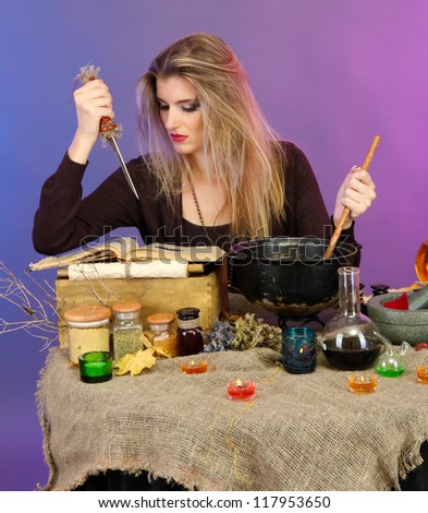 Halloween witch stirring in poison soup in her cauldron on color background