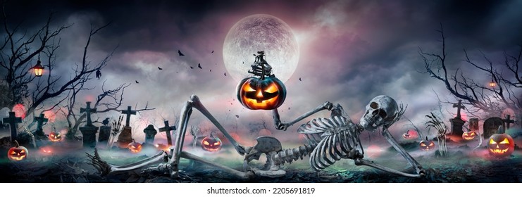 Halloween - Zombie Skeleton With Pumpkin In Hand Sitting On Cemetery At Night With Full Moon - Shutterstock ID 2205691819