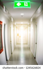 Hallway In Apartment With Door Rooms In Dorm , Fire Exit Green Light Sign