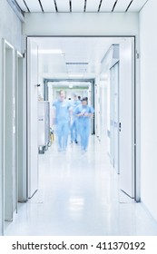 Hallway With The Door Open To The Intensive Care Unit At The Hospital With Blurred Doctors From OP