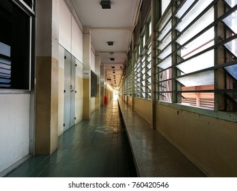 hallway with green floor window tile on the left and doors to the room on the right and orange light at the end of the corridoor - Shutterstock ID 760420546