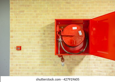 in the hallway of a nice building, there is an fire hose