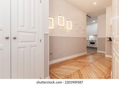 Hallway Of A Vacation Rental House With A Built-in Closet With White Wooden Doors And Beautiful Pine Wood Flooring