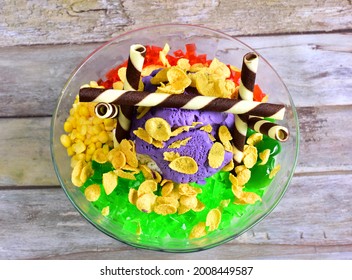 Halo Halo :A Filipino dessert made with mixed fruits, boiled sweetened white beans, milk, and flavoured crushed ice, typically topped with purple yam, crème caramel, and ice cream. - Shutterstock ID 2008449587