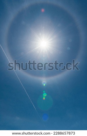 Halo and contrails in blue sky