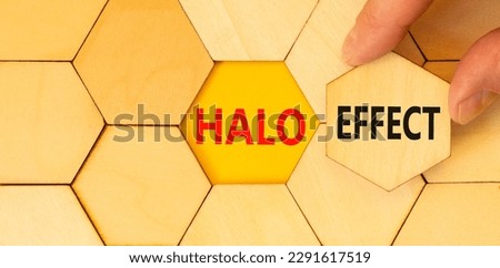 Halo effect and psychological symbol. Concept words Halo effect on wooden puzzles. Beautiful yellow table yellow background. Businessman hand. Business psychological Halo effect concept. Copy space.