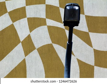 halogen street light and lamp post in front of abstract, vasarely-like stucco exterior elevation detail in yellow and white colors