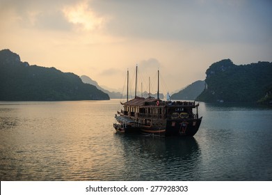 Halong Bay Sunrise And Vietnam Traditional Boat.