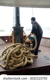 HALONG BAY, VIETNAM - FEB 2, 2015 - Crewman Hauling In The Anchor On Cruise Ship Junk,  Halong Bay, Vietnam