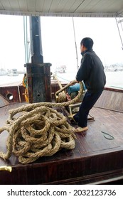 HALONG BAY, VIETNAM - FEB 2, 2015 - Crewman Hauling In The Anchor On Cruise Ship Junk,  Halong Bay, Vietnam