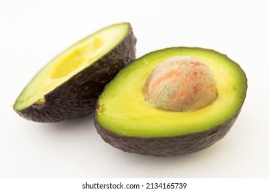 halved avocado with bone on white background - Shutterstock ID 2134165739