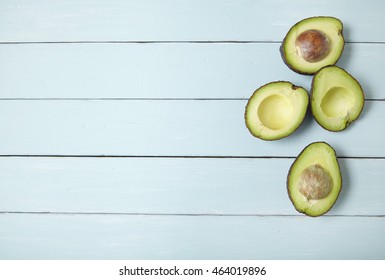 Halved Avocados On A Painted Wooden Kitchen Counter Background Forming A Page Border