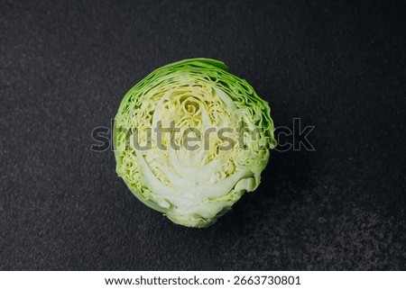 Halved cabbage with concentric leaf layers on black background
