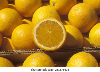 A halved orange rests on oranges in boxes in Ventura County ,CA