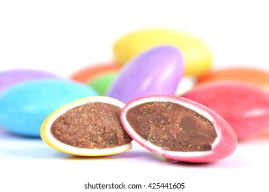 Halved Red And Yellow Smarties With Chocolate Filling And Blue, Purple, Yellow In Background