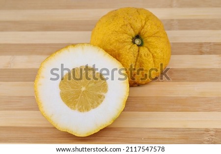 Halves of a citron fruit on a two tone cutting board. Its scientific name is Citrus medica.