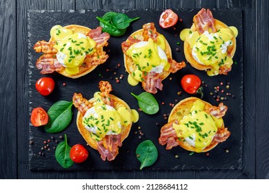 halves of an English muffins, each topped with canadian bacon, a poached egg, and hollandaise sauce, Eggs Benedict