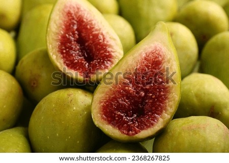 Halves of green fig on fresh fruits, closeup
