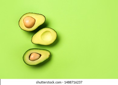 Halves Of Ripe Avocado On Color Background