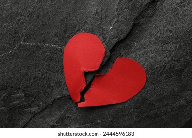 Halves of torn red paper heart on dark grey table, top view. Broken heart - Powered by Shutterstock