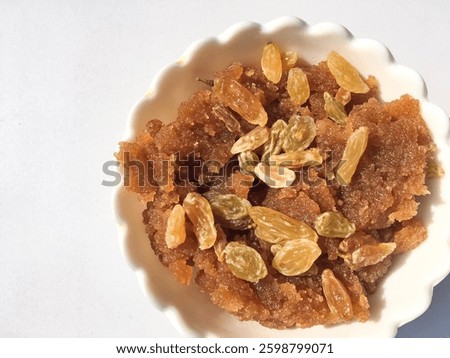 Halwa or Pudding with white isolated background, Halwa a sweet indian dish consisting semolina boiled with milk and topping of Raisin's, sereved for eid ul fitr ,eid mubarik, Eidmubarak