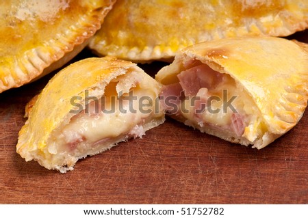 Ham and Cheese Empanada fill close up.  The Empanada is a pastry turnover filled with a variety of savory ingredients and baked or fried.