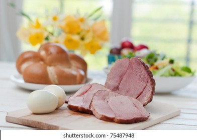 Ham On Easter Table With Eggs, Flowers And Decoration