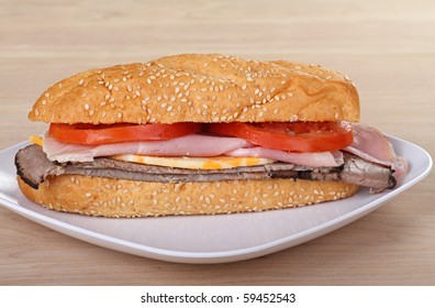 Ham And Roast Beef Sub With Tomatoes And Cheese On A Sesame Seed Bun