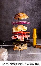 Ham Sandwich With Lettuce, Cheese, Red Onion, Tomato On Artisan Bread. Floating Layers. Dark Background.