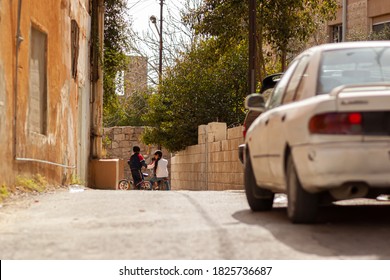 Hama, Syria 04/02/2010: Despite Cars Using The Road, Kids Are Playing And Riding Their Bikes On A Narrow Street In An Old And Poor District Of Hama Which Causes Safety Concerns.