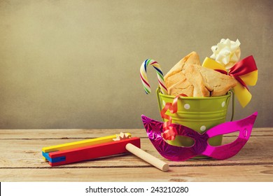 Hamantaschen Cookies In Bucket With Grogger Noise Maker And Carnival Mask. Gift For Purim Festival