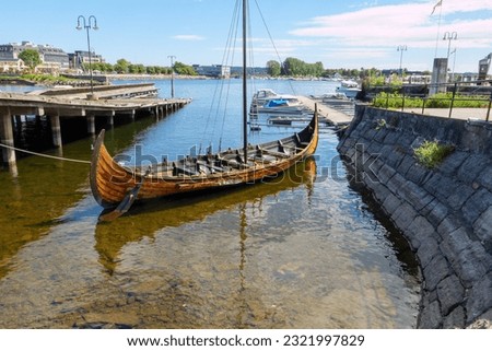 Hamar harbor on Mjøsa In the foreground an old wooden rowboat. Mjøsa is the largest lake in Norway. Seen on the pilgrimage route St. Olavsweg from Oslo to Trondheim.