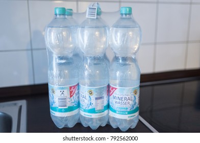 Hamburg, Germany - 01/13/2018 Sixpack Of 1.5 Liter Nonrefillable PET Deposit Bottles Of EDEKA Sparkling Mineral Water In Shrink Wrap On Kitchen Counter 