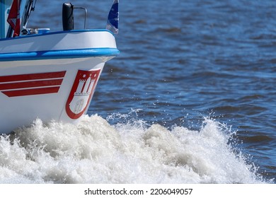 Hamburg, Germany, 04-21-2019: Bow Of A Ship With The Coat Of Arms Of The City Of Hamburg And A Bow Wave.