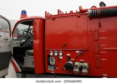 Hamburg, Germany 08 27 2022: View On Vintage Red Fire-brigade Truck With Open Door Of Driver Cabin And Blue Light. On The Side Are Visible Couplings For Fire Hoses And Other Firefighting Equipment. 