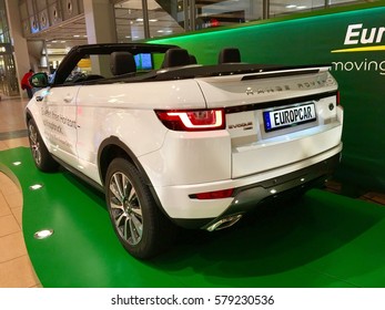 Hamburg, Germany - February 10, 2017: New white luxury Range Rover Evoque car with convertible top stands on advertising place in airport terminal as a car for rent by Europcar, rear view