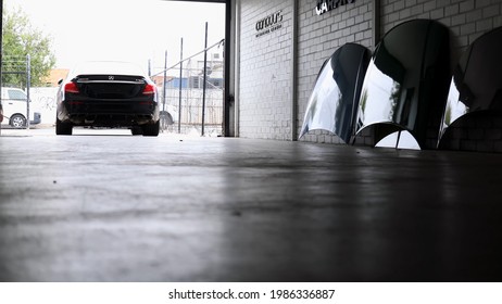 Hamburg, Germany - January 12 2021: A Black Mercedes Car That Is About To Go Backwards Into A Garage And Car Hoods Inside The Garage.