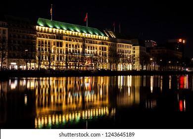 HAMBURG, GERMANY - MARCH, 2018: The Fairmont Hotel Vier Jahreszeiten located on the western side of the Inner Alster Lake shore at night time